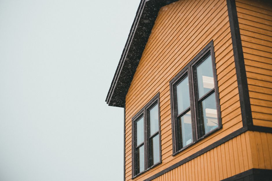 Exterior of a house with dark trim around its windows.