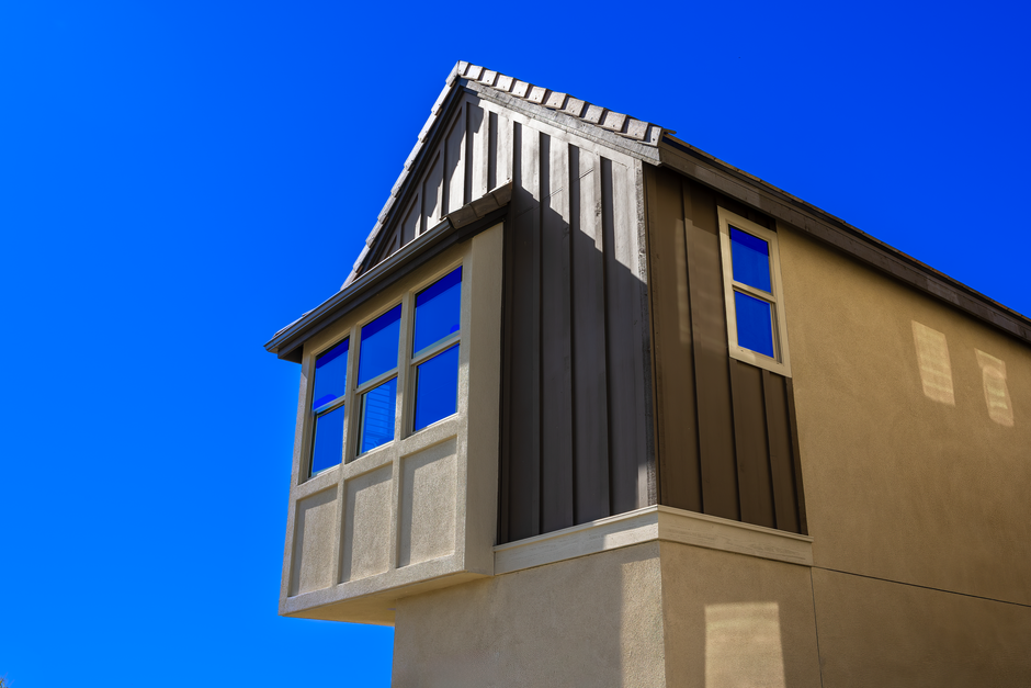 Low angle shot of a modern residential building facade against a clear blue sky.